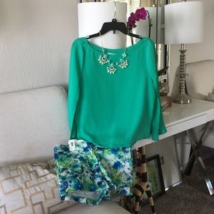 Cape sleeve top, floral shorts, and necklace